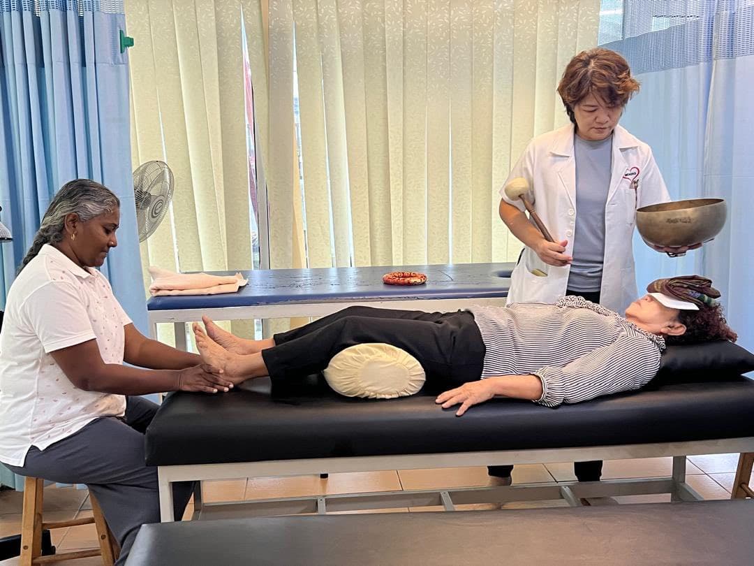 MHHO practitioners delivering reflexology and sound vibration therapy in the treatment room